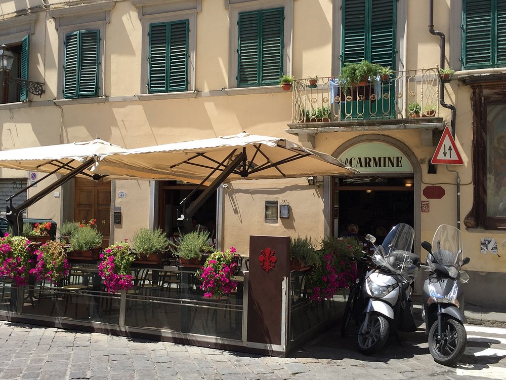 La facciata della Trattoria del Carmine con gli ombrelloni e i fiori, in Piazza del Carmine